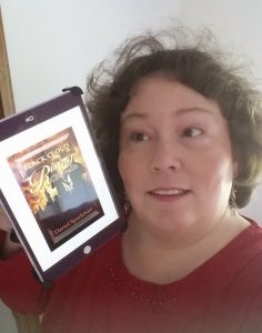 Ronda Del Boccio holding the Kindle edition of Black Cloud Rising: CHrytsalis  by Darrel Sparkman, showing the cover